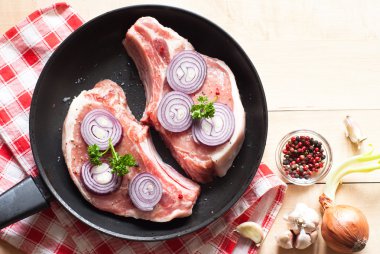 Bir tavada çiğ domuz eti.