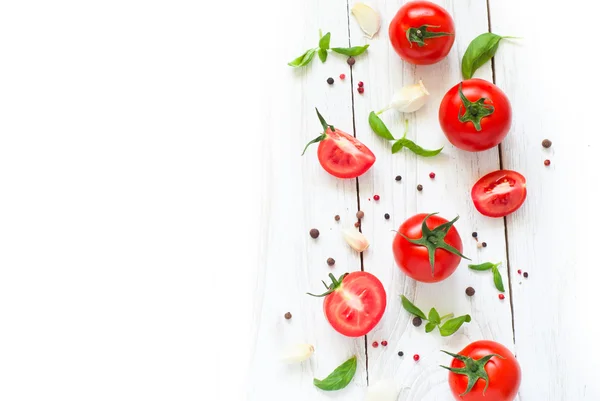 Pomidory, bazylia i czosnek na biały drewniany stół — Zdjęcie stockowe
