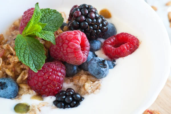 Йогурт з гранолою та свіжими ягодами — стокове фото