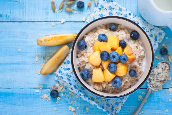 Farina d'avena con pesca e mirtilli . — Foto Stock