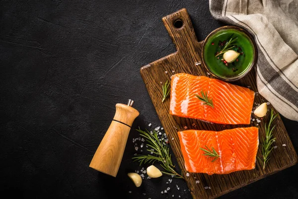 Peixe de salmão com ingredientes à mesa preta. — Fotografia de Stock