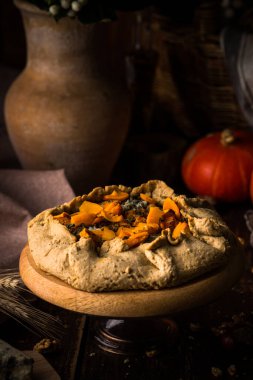 Ahşap masada küflü peynirli balkabağı turtası.