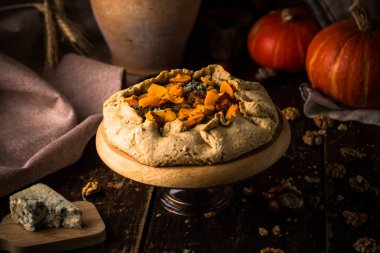 Ahşap masada küflü peynirli balkabağı turtası.