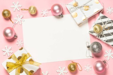 Şimdiki kutu ve dekorasyonlarla Noel pembe düz arka planı.