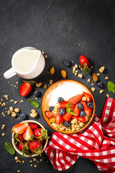 Grecki jogurt granola ze świeżymi jagodami na czarnym kamiennym stole. — Zdjęcie stockowe