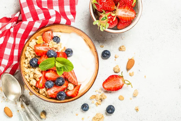 Grecki jogurt granola ze świeżymi jagodami na białym kamiennym stole. — Zdjęcie stockowe