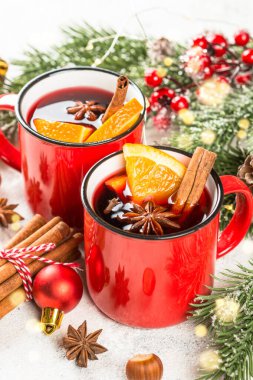 Kırmızı bardaklarda sıcak şarap ve Noel süslemeleri..