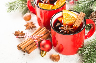 Kırmızı bardaklarda sıcak şarap ve Noel süslemeleri..