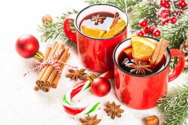 Kırmızı bardaklarda sıcak şarap ve Noel süslemeleri..