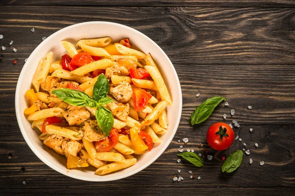 Tahta masada tavuk ve sebzeli makarna..