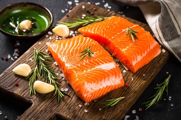 Peixe de salmão com ingredientes à mesa preta. — Fotografia de Stock