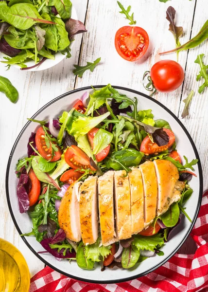 Insalata verde con petto di pollo al forno a tavola bianca. — Foto Stock