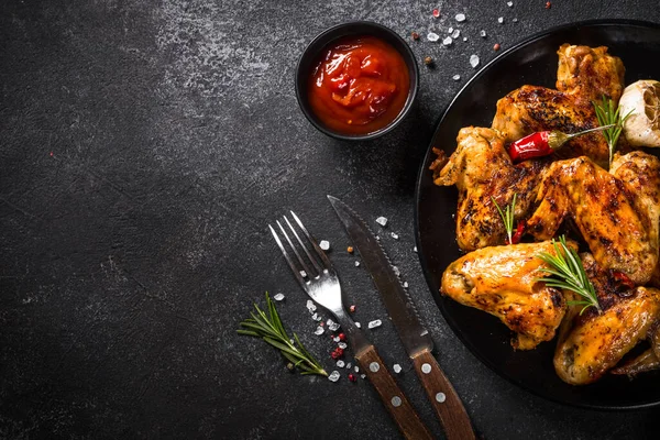 Gegrillte Chicken Wings mit Gewürzen am schwarzen Tisch. — Stockfoto