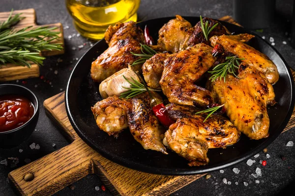 Ali di pollo alla griglia con spezie in piatto nero. — Foto Stock