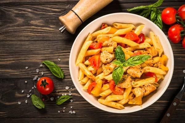 Tahta masada tavuk ve sebzeli makarna..