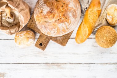 Beyaz masada taze ekmek ve çörekler.