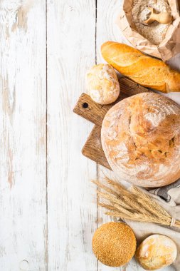 Beyaz masada taze ekmek ve çörekler.
