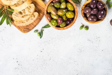 Beyaz arka planda zeytin, ciabatta ve zeytinyağı.