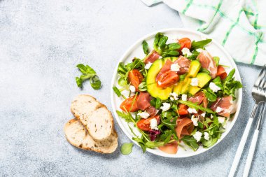 Yeşil yapraklı taze salata, jamon ve domates..