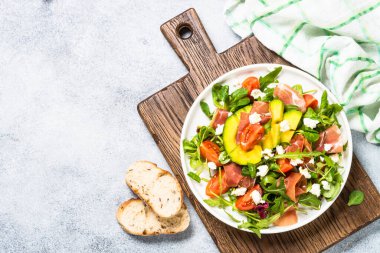 Yeşil yapraklı taze salata, jamon ve domates..