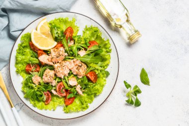 Beyaz masada fırında balık ve yeşil salata..