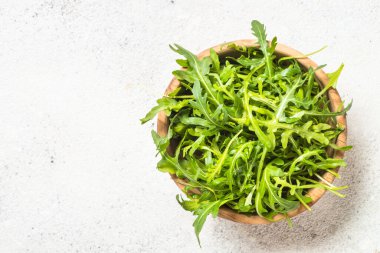 Arugula beyaz masada taze yeşil yapraklar.