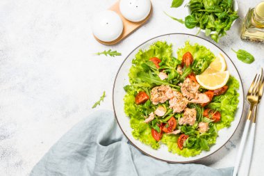 Beyaz masada fırında balık ve yeşil salata..