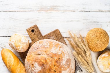 Beyaz masada taze ekmek ve çörekler.