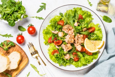 Beyaz masada fırında balık ve yeşil salata..