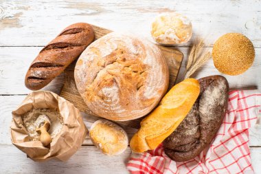 Beyaz masada taze ekmek ve çörekler.