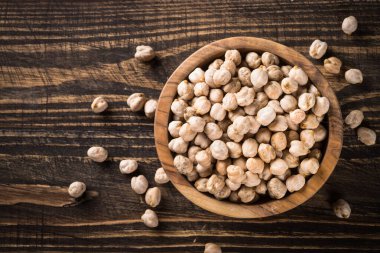 Ahşap mutfak masasında, beyaz kasede nohut..