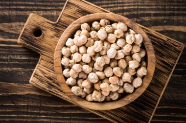 Ahşap mutfak masasında, beyaz kasede nohut..