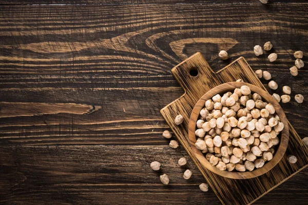 Ahşap mutfak masasında, beyaz kasede nohut..