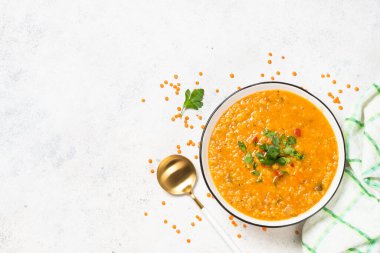 Beyaz taş masada sebzeli mercimek çorbası.