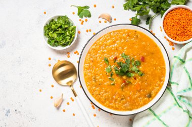 Beyaz taş masada sebzeli mercimek çorbası.