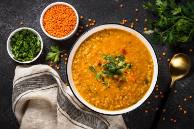 Siyah taş masada sebzeli mercimek çorbası..