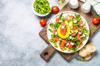 Yeşil yapraklı taze salata, jamon ve domates..