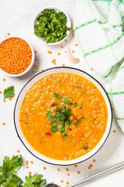 Beyaz taş masada sebzeli mercimek çorbası.
