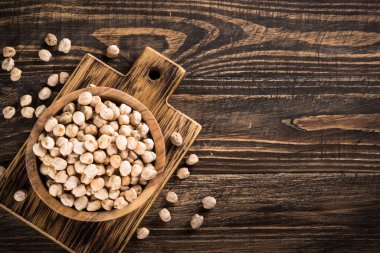 Ahşap mutfak masasında, beyaz kasede nohut..