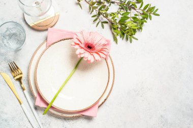 Masa ayarları beyaz tabak, çatal bıçak ve çiçeklerle.