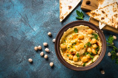 Mutfak masasında zeytinyağı ve pide ile humus..