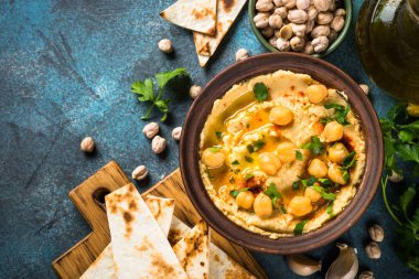 Mutfak masasında zeytinyağı ve pide ile humus..