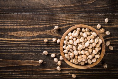 Ahşap mutfak masasında, beyaz kasede nohut..