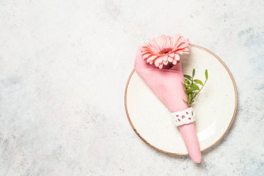 Masa ayarları beyaz tabak, çatal bıçak ve çiçeklerle.