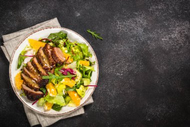 Fırında ördek, yeşil salata ve portakallı salata..