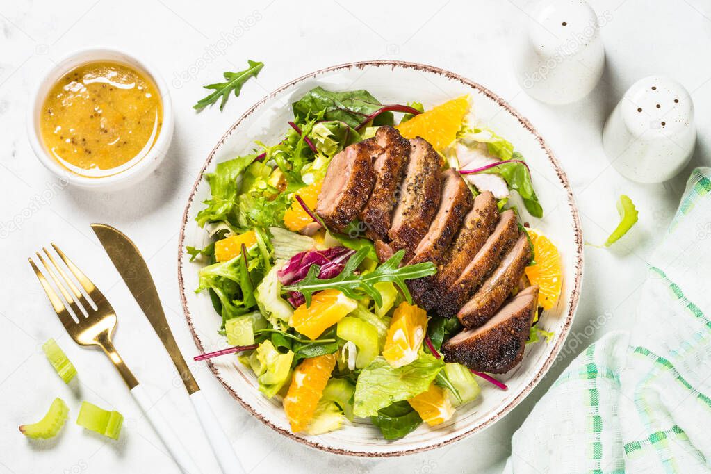 Salad with baked duck, green salad mix and oranges.