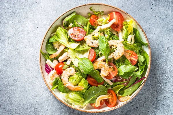 Shrimp salad with green leaves at stone table. — Stock Photo, Image