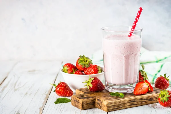 Erdbeer-Smoothie oder Milchshake am weißen Tisch. — Stockfoto