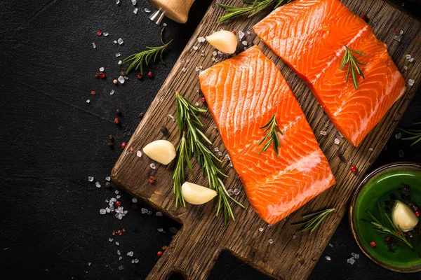 Peixe de salmão com ingredientes à mesa preta. — Fotografia de Stock