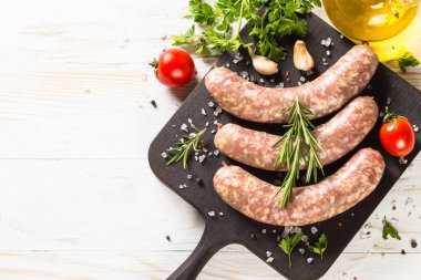 Sosis ya da sosis beyaz ahşap masadaki tahtayı keser..